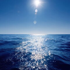 Bright Sun Reflecting on Deep Blue Ocean Waves Under Clear Sky