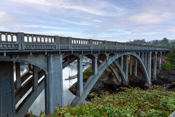 Obraz premium Highway 395 Arch bridge over the entrance of the Depoe Bay Oregon Harbor.