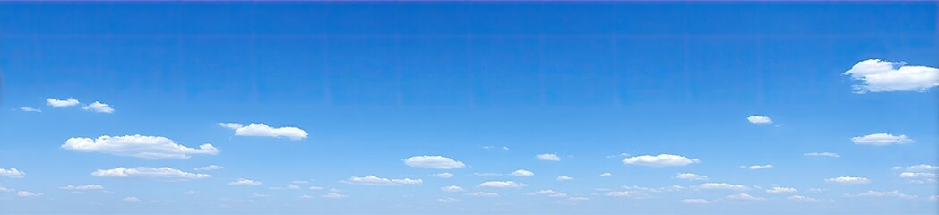 A vast expanse of clear blue sky dotted with scattered, fluffy white clouds