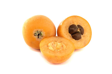 Fresh loquat fruit, whole and cut, showing seeds, isolated on white
