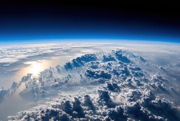 Earth's curvature is visible with cloud layers below, sky fading into deep blue and black, sunlight reflecting off water. High altitude perspective