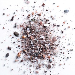 A scattering of assorted small rocks and granular material on a white surface, viewed from directly above