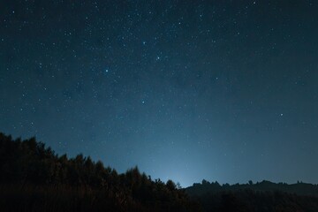 Fototapeta premium Starry night over a dark hillside