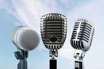 three microphones at blue sky background