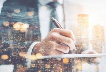 Businessman signing document, city lights blurred background