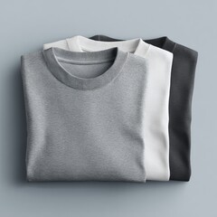 Three folded t-shirts, grey, white, black
