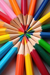 Naklejka premium Vibrant colored pencils arranged in a circular pattern, showcasing a spectrum of hues.