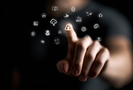 Hand points to a digital cloud icon amid other technology icons against a dark background, focusing on connectivity