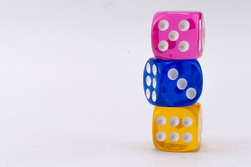 Stacked Dice - Pink, Blue, and Yellow Dice Tower on White Background, Game of Chance, Colorful Cubes.