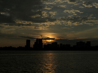 Moody Sunset Silhouette Over City and Lake &mdash; Stormy Clouds, High Contrast, Cinematic Atmosphere