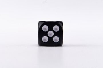Black Dice with Five White Pips on a White Background, Close-up Studio Shot.
