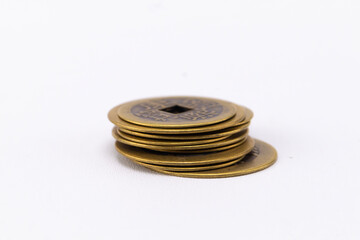 Stack of Antique Chinese Coins with Square Hole on White Background.