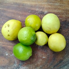 Fresh Lemons and Limes on Wooden Background – Citrus Fruits