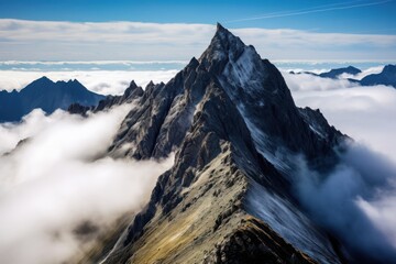 Jagged mountain peak piercing through clouds sharp rock