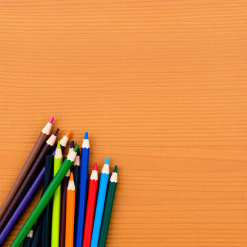 colored pensils on a brown table. drawind on a wooden background