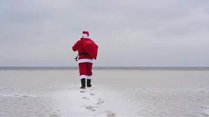 Santa Claus Walks a Snowy Beach on a Cloudy Day