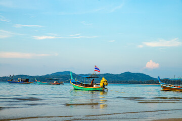 Fototapeta premium Tranquil Fishing Boats Resting on a Peaceful Beach at Sunset in Beautiful Thailand