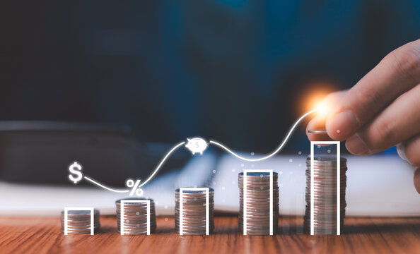 Hand arranging a glowing line graph over coin stacks, symbolizing financial growth, investment success, and smart savings strategies for future wealth management.