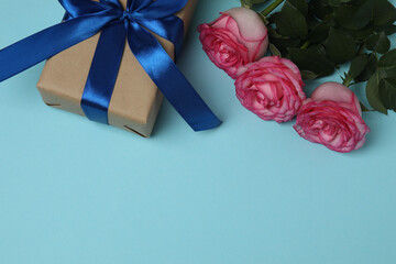 Pink rose with gift on blue background
