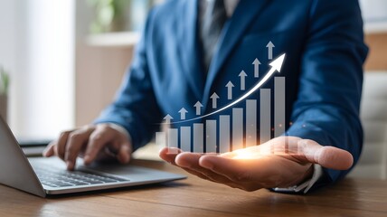 Businessman In Blue Suit Using Laptop With Virtual Growing Graph Bar Chart Showing Success And Financial Growth Concept