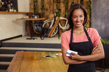 African American barista standing in cafe holding notepad and pen beside espresso cup, copy space