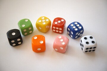 Group of multicolored dice arranged on a white background with copy space.