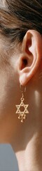 Fototapeta premium Authentic Jewish Star of David Gold Earring Close-Up for High-Quality Hanukkah and Black Friday Holiday Marketing Targeting Millennials with Modern Lifestyle Appeal