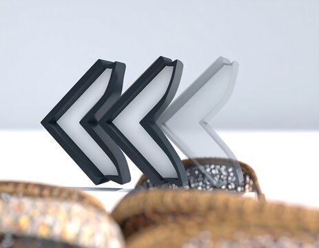 Three overlapping left-pointing arrows on a light-gray background, with blurred objects in the foreground