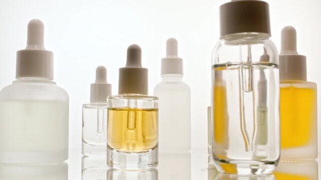 Cosmetic spa. Glass bottle with pipette for collagen serum, liquid, emulsion on the mirror table. Cosmetics oils based on natural ingredients. Natural cosmetics production for hair and skin care. 4k