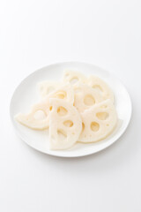 皿に乗ったレンコンの半月切り　白バック