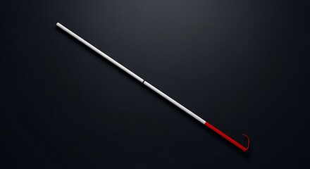 Naklejka premium A white cane with a red handle lies diagonally on a dark background
