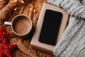 A cell phone is on a table next to a cup of coffee