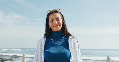 Portrait, tourist and woman on vacation, beach or happy on weekend, tourism and fresh air in nature. Calm, traveller and person on holiday, space and smile on break, sea and outdoor in paradise