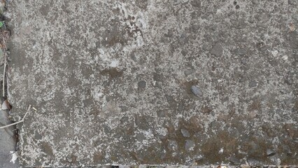 Close-up of a rough, weathered concrete surface with small stones and natural erosion. This raw texture is ideal for use in 3D modeling, digital artwork, architecture references, or urban backgrounds.