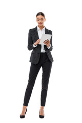Full length businesswoman in elegant suit holding and looking at tablet with online trading charts. Confident and professional. Beautiful smile. Transparent background.