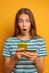 Woman is holding a cell phone and a credit card, looking surprised.  Black Friday and Cyber Monday shopping concept