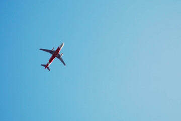 Soaring Flight: An airplane gracefully traverses a vast, clear blue sky, offering a dynamic perspective of air travel, with its wings and fuselage defined against the expanse.