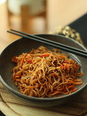 Stir-fried instant noodles with vegetables and meat, a quick and flavorful Thai comfort food dish loved for its savory taste.