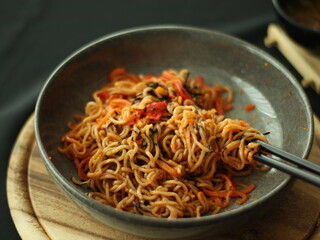 Stir-fried instant noodles with vegetables and meat, a quick and flavorful Thai comfort food dish loved for its savory taste.
