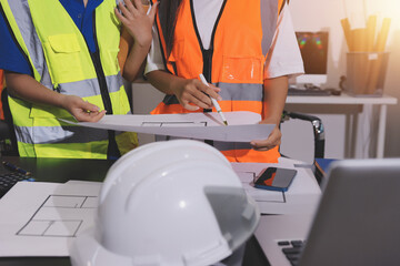 Closeup of team of industrial engineers meeting analyze machinery blueprints consult project on...