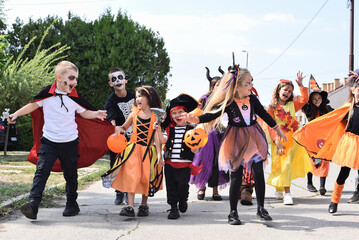 Children walking in the city picking up candy on Halloween