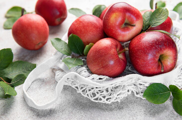 Fresh red apples resting in a reusable shopping bag