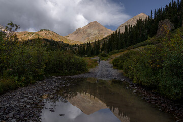 Fototapeta premium Beautiful mountain landscape with clouds and lake reflection at Colorado Yankee Boy Basin Pass