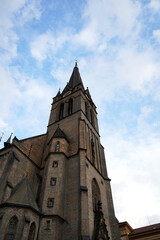 Tall stone church with pointed spire and gothic design, representing spiritual heritage, historic architecture, and cultural significance