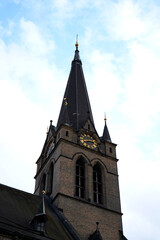 Obraz premium Historic church tower with tall spire and clock, symbolizing heritage, spirituality, and timeless architectural craftsmanship.