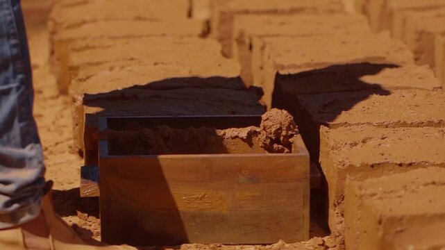 Construction worker making adobe bricks using traditional techniques in Chapada dos Veadeiros, Brazil, promoting sustainable building practices and cultural preservation, slow motion shot