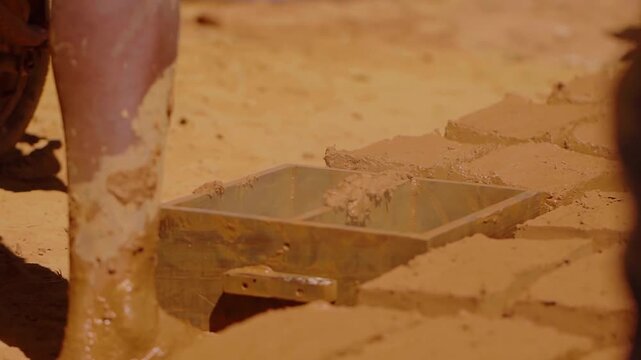Construction worker making adobe bricks using traditional methods in Chapada dos Veadeiros, Brazil, promoting sustainable and culturally relevant building techniques