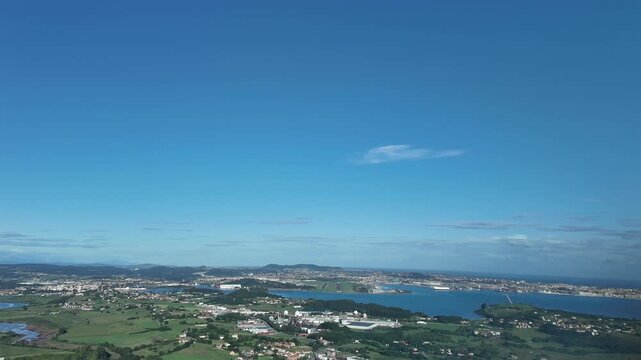 An immersive pilot eyes FPV view from a jet cockpit i stablished in the long final approach to Santander airport runway RWY29 viith a view of the bay and the city under. a blue sky.