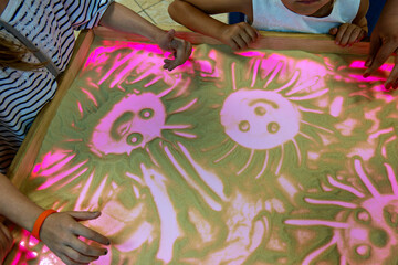 This image shows a group of people interacting with a light-up table