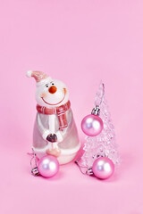 a card with a beautiful transparent Christmas tree decorated with pink balls and a cute snowman next to it, pink background, vertical, creative focus